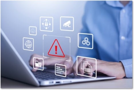 hands on a laptop with floating symbols on tiles in front of the screen