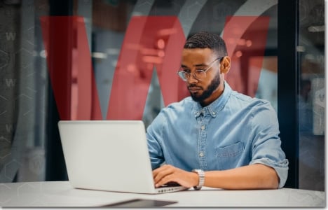 black man working on a laptop in an open office