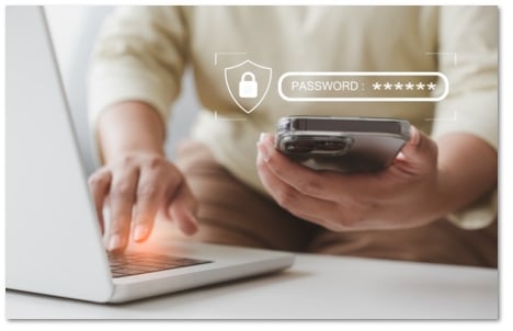 Someone using a phone with a password prompt floating above it to log into a laptop