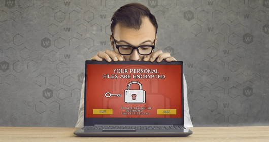 Man looking over a laptop screen with a locked red display