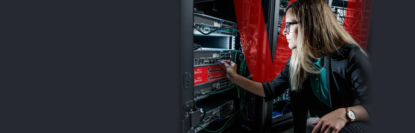 blonde woman reaching for a red Firebox in a server rack